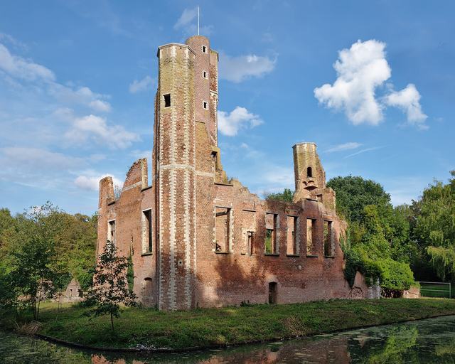 De bakstenen ruïne van kasteel Ter Elst tussen het groen
